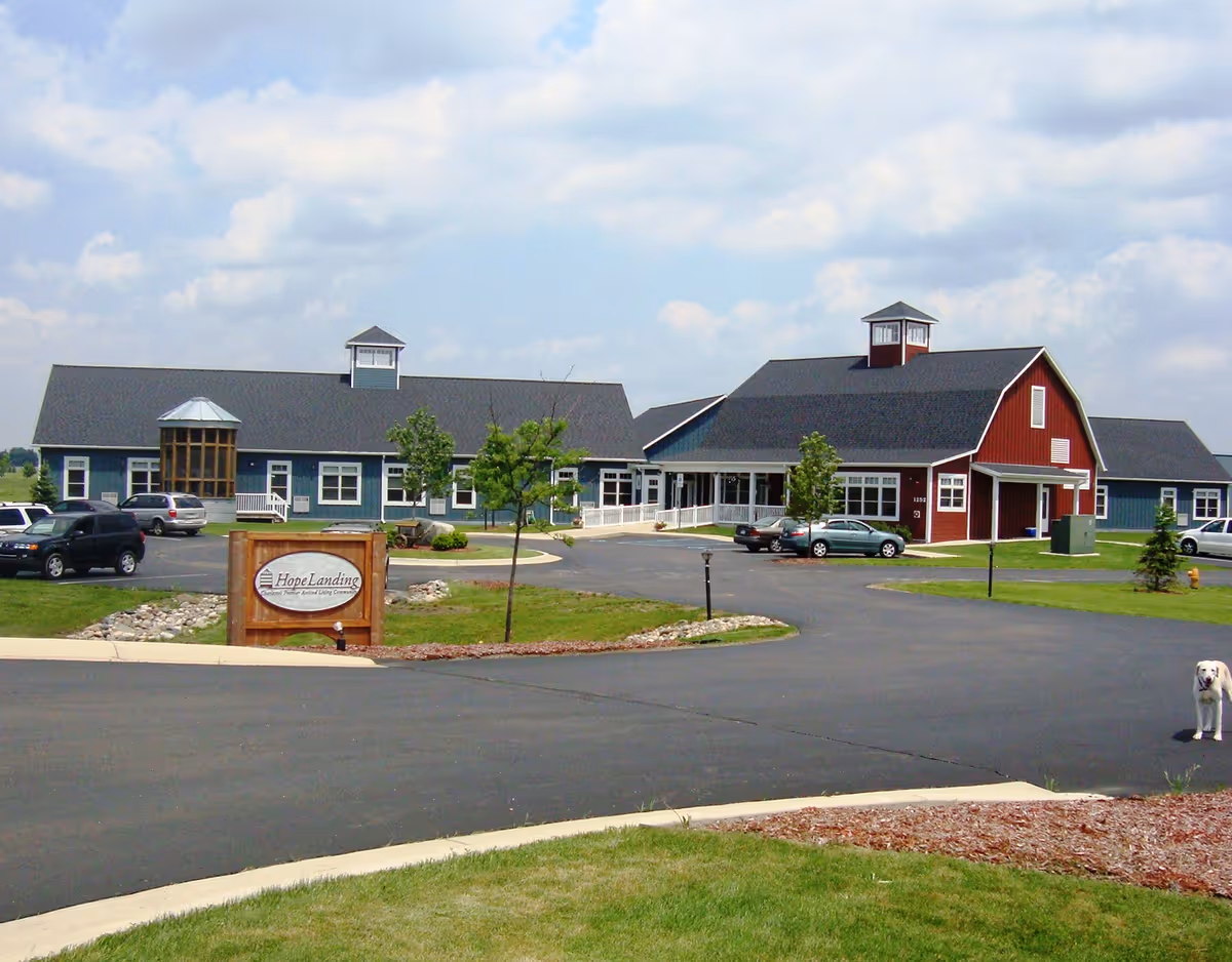 Exterior view of Hope Landing senior living facility with blue wings and red entry
