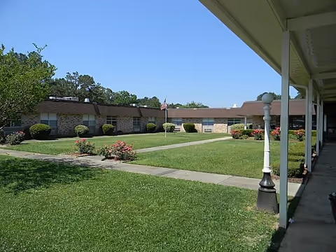 Exterior view of Selma Health and Rehab, a single-story building with lawn, walkway, and flag.
