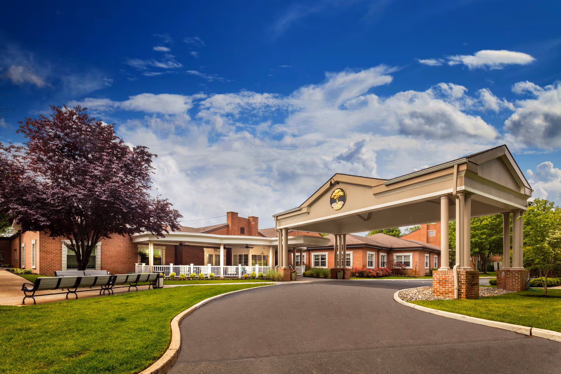 Exterior view of Paul's Run senior living facility with a porte-cochere entrance and benches.