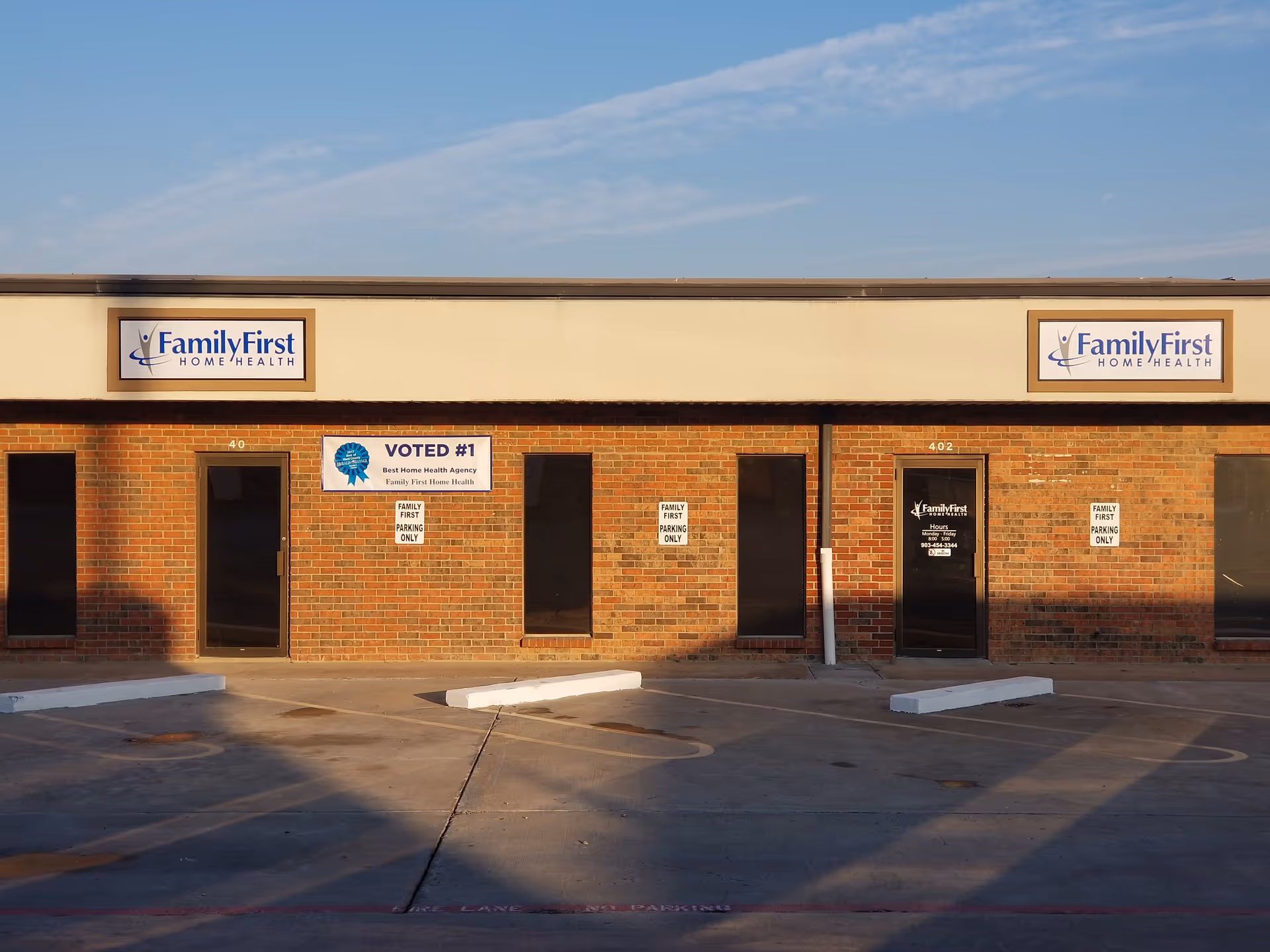 Brick storefront of FamilyFirst Home Health with signs and a parking lot.