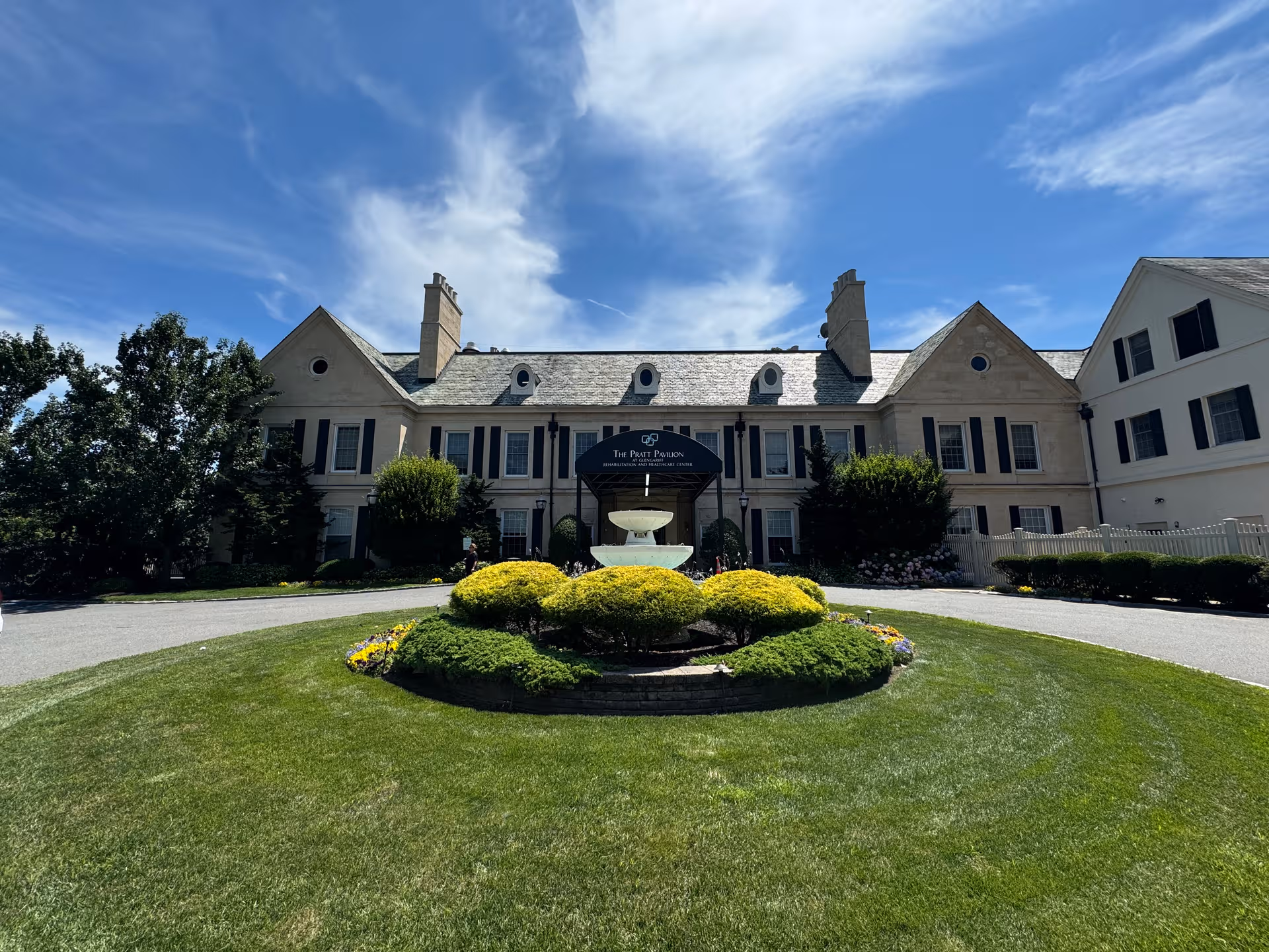 Front exterior of Glengariff Rehabilitation Center with circular driveway, central fountain, and landscaped greenery.