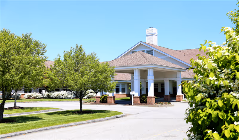 Exterior view of Putnam Ridge facility with a covered entrance and green trees.