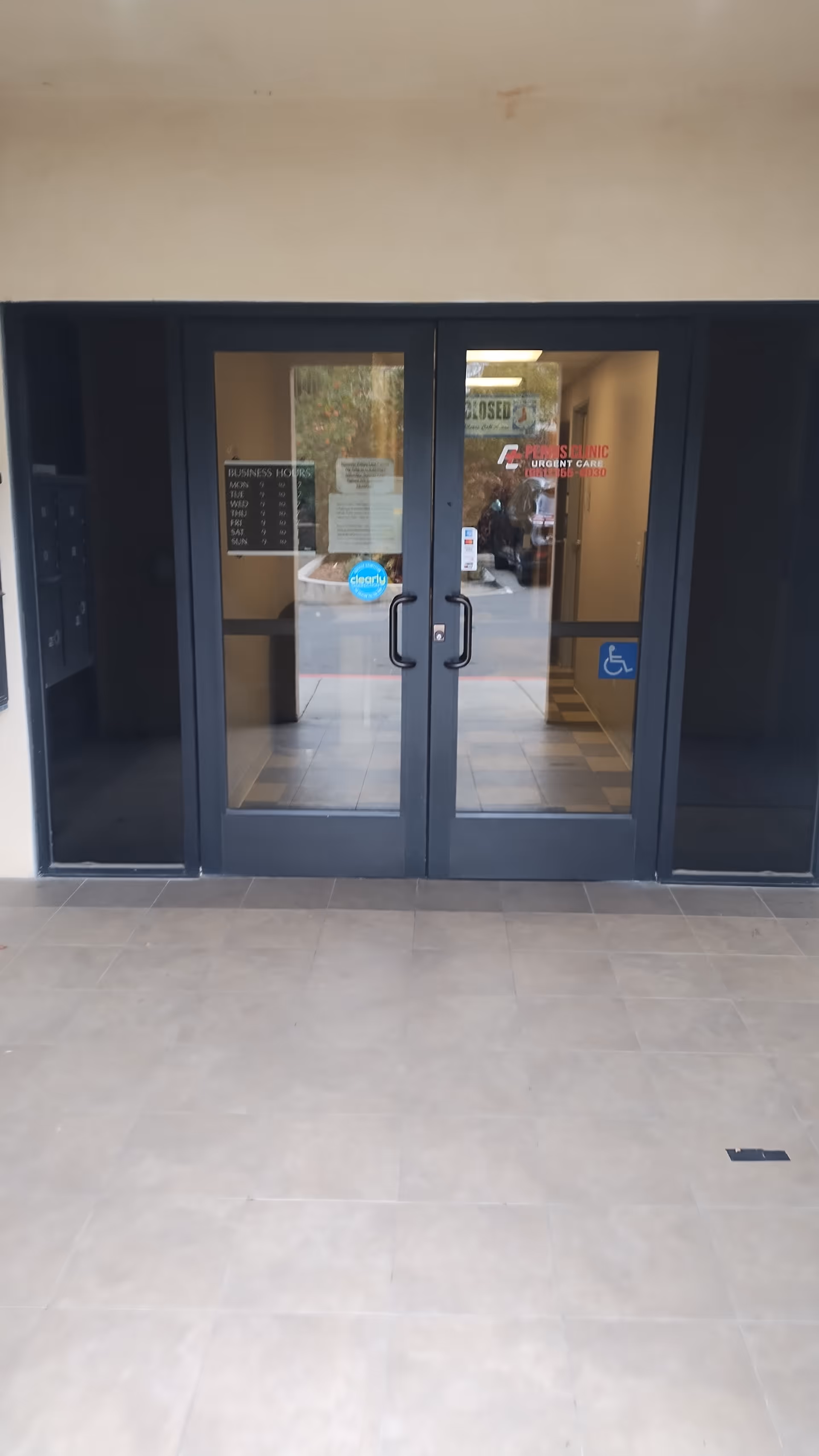Glass double doors with handicap sign greet visitors at Perris Urgent Care.