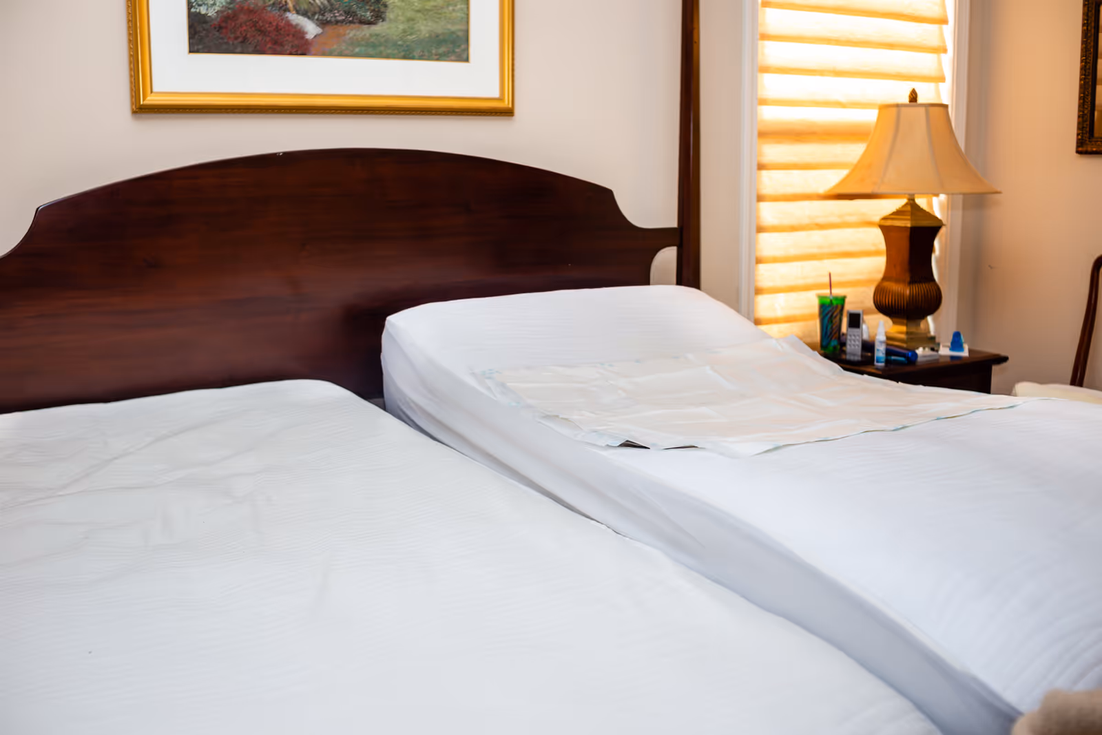 Two neatly made beds and a nightstand in a cozy senior living bedroom.