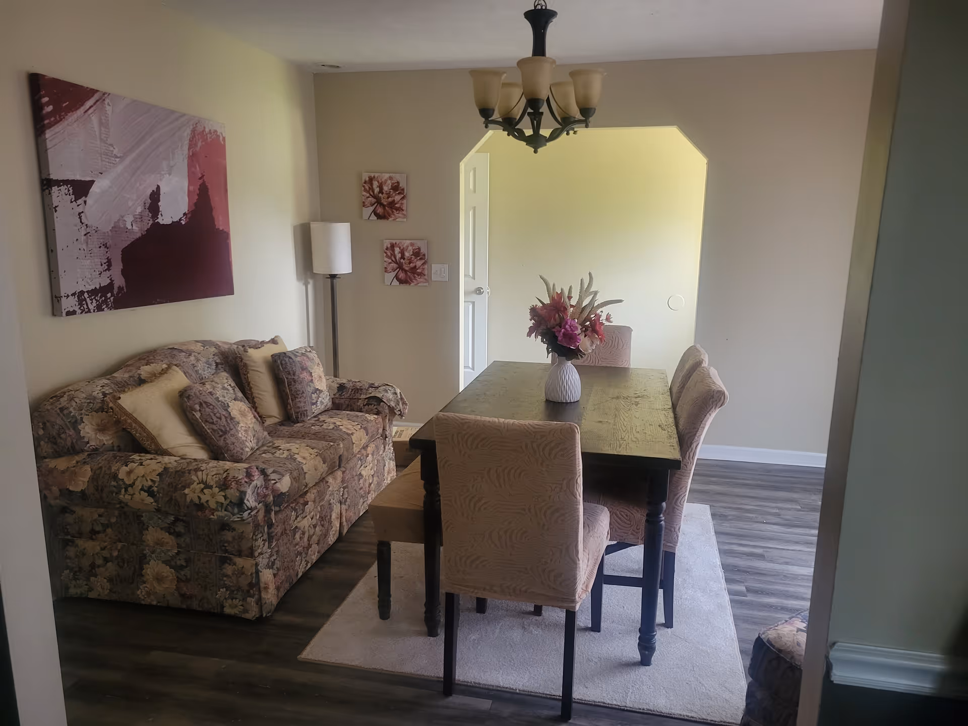 Floral sofa and dining table in a cozy, well-lit living area.