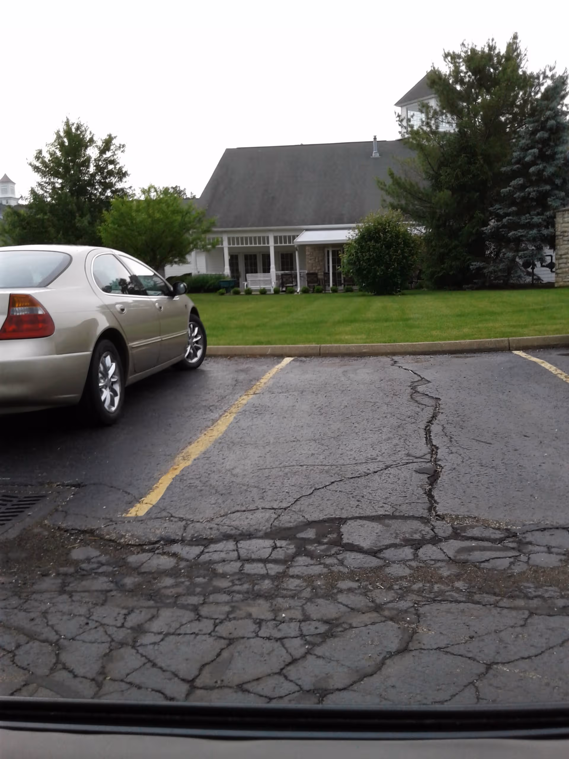 Exterior view of Marian Living Center with a parked car and green lawn.