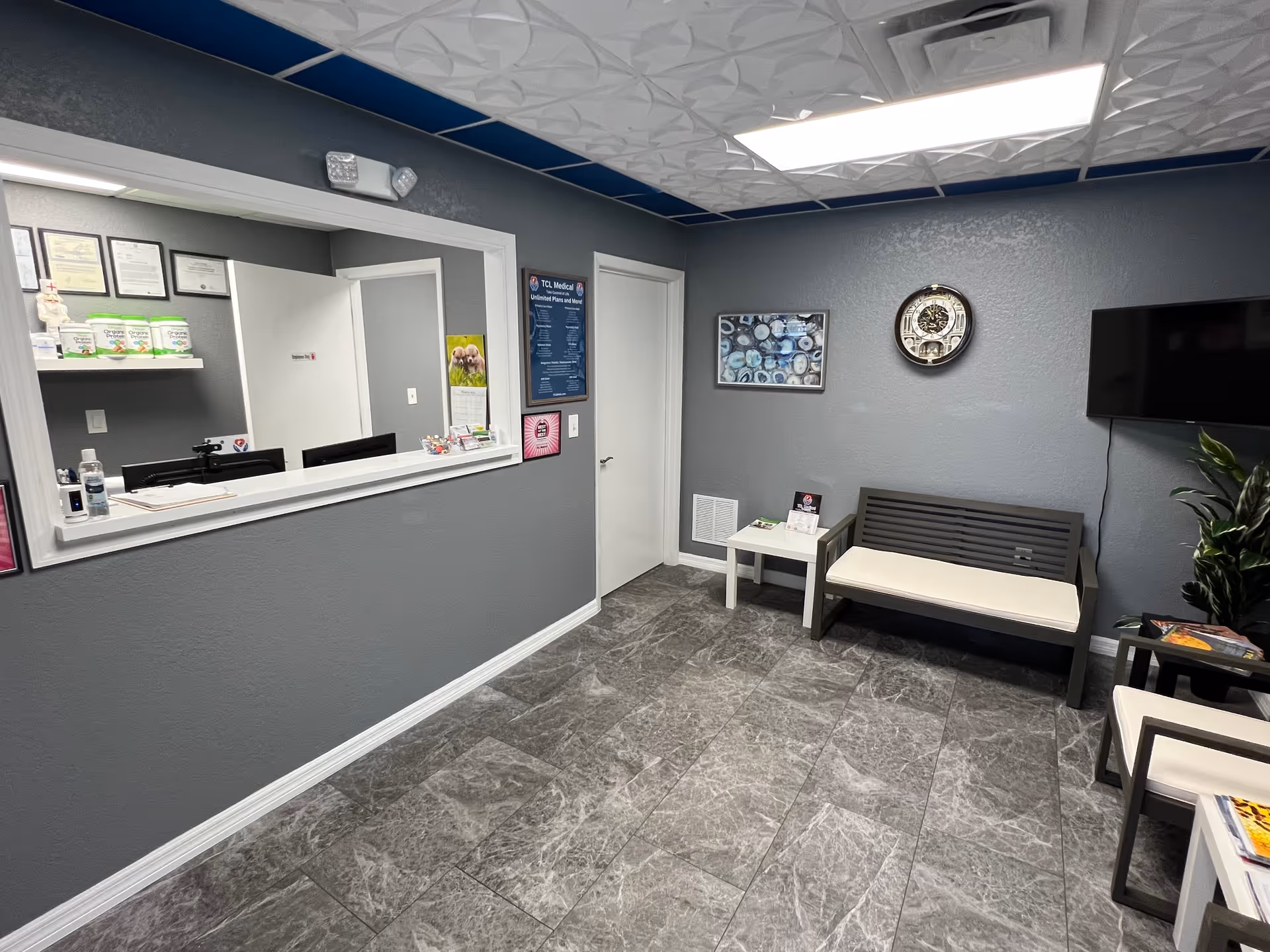 Reception area of TCL Medical with a front desk, seating, and wall decor.