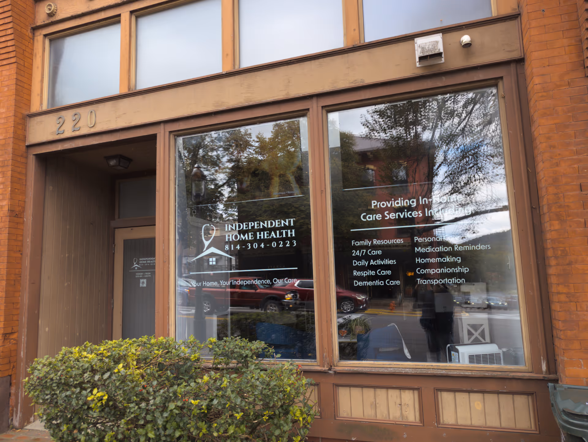 Brick storefront with large glass windows displaying Independent Home Health signage