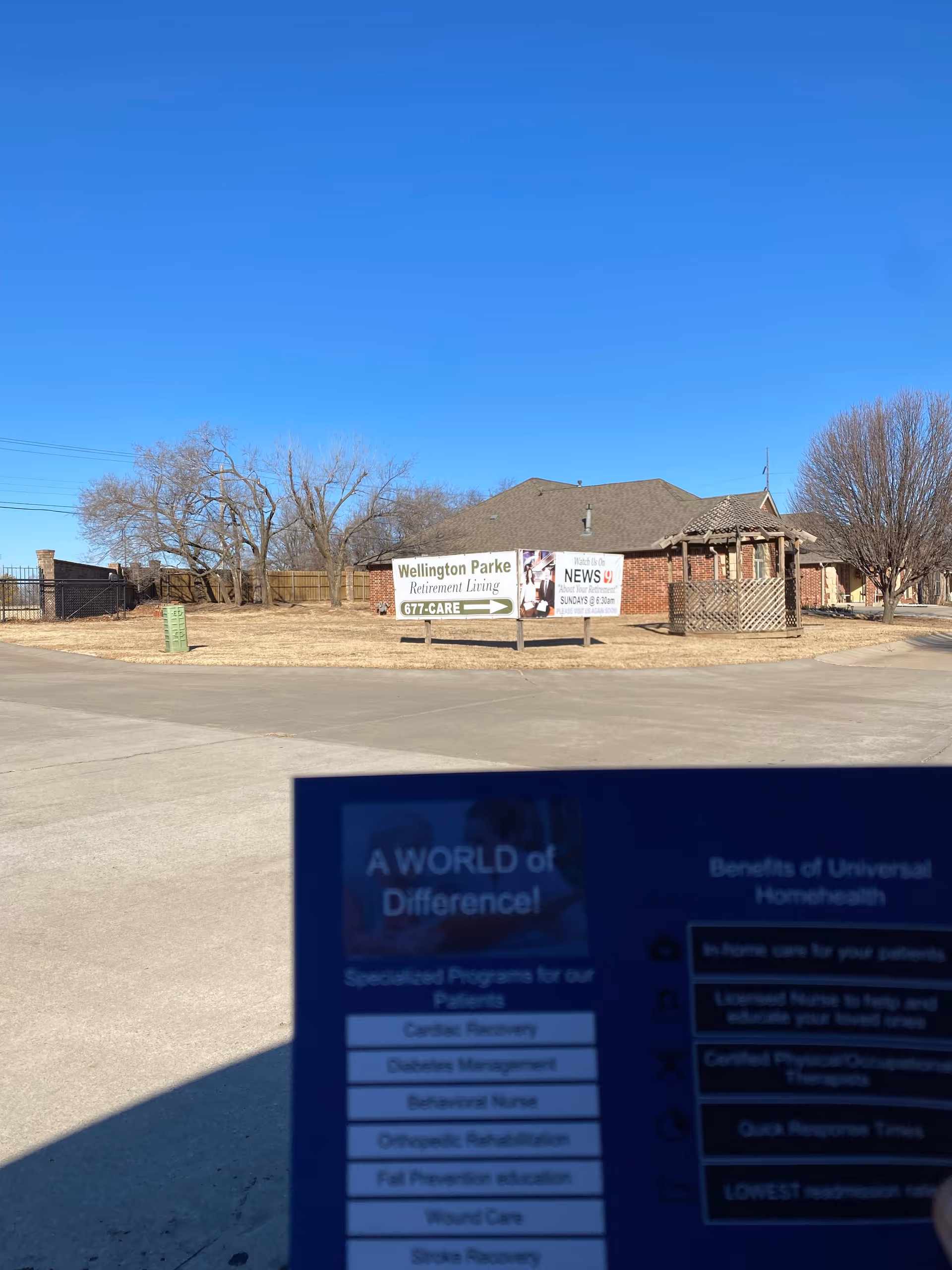 Exterior view of a retirement living facility with banners and a blue sky.