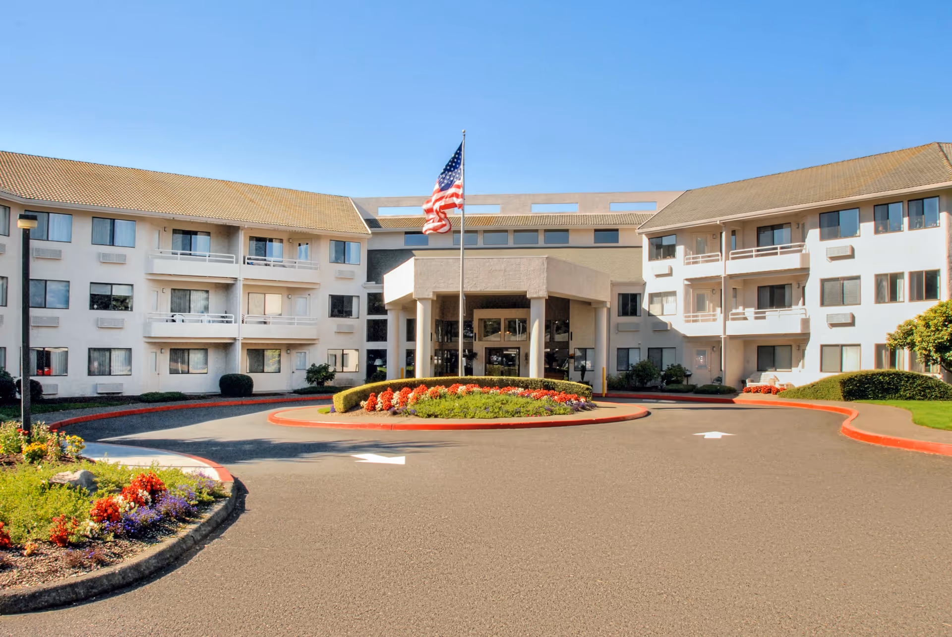 Exterior view of Solista Gresham facility with circular driveway and American flag.
