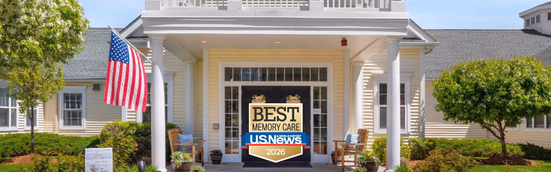Exterior view of The Atrium at Drum Hill entrance with American flag and award sign.
