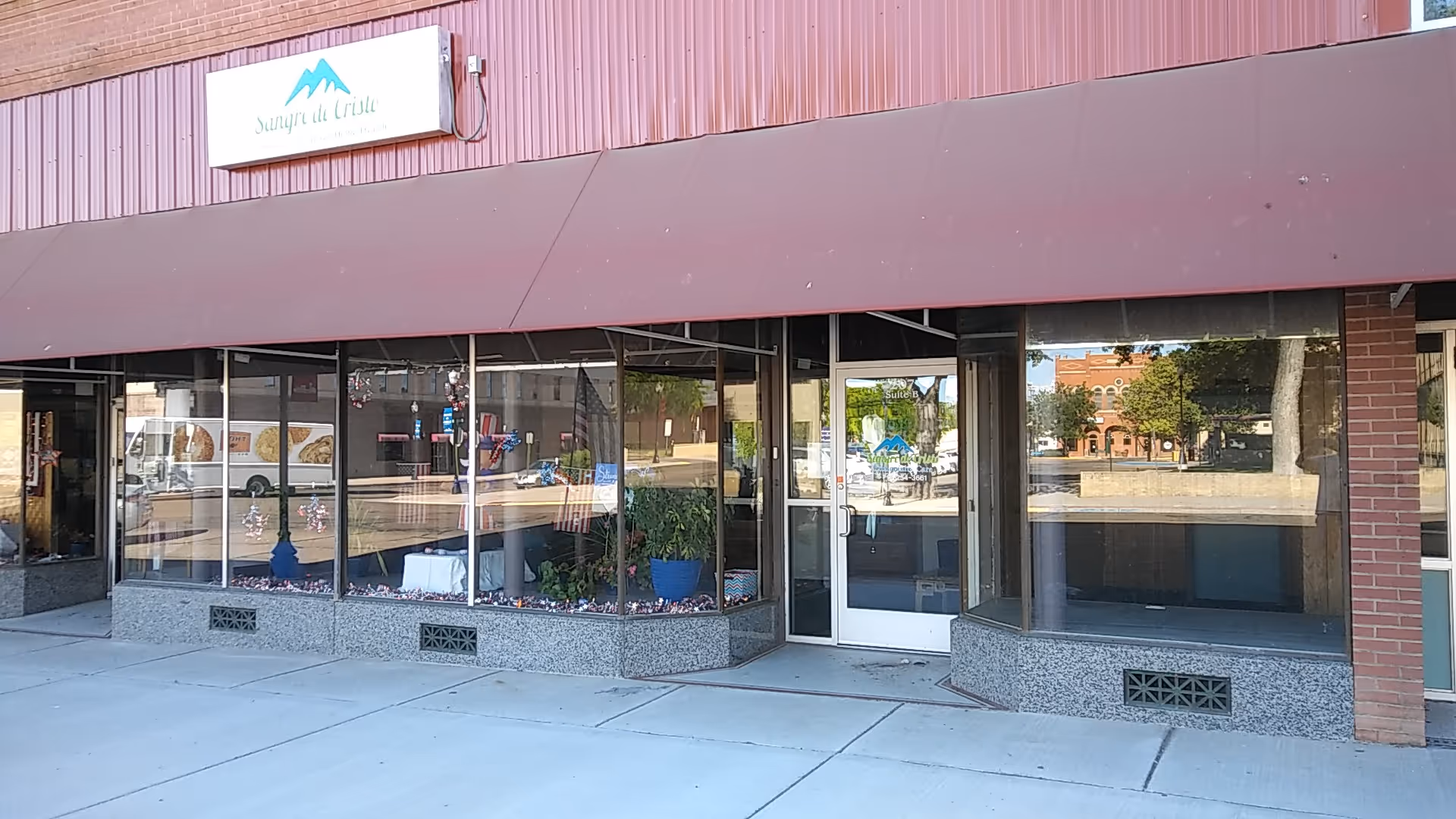 Exterior view of Sangre de Cristo Community Care storefront with large windows and an entrance door.