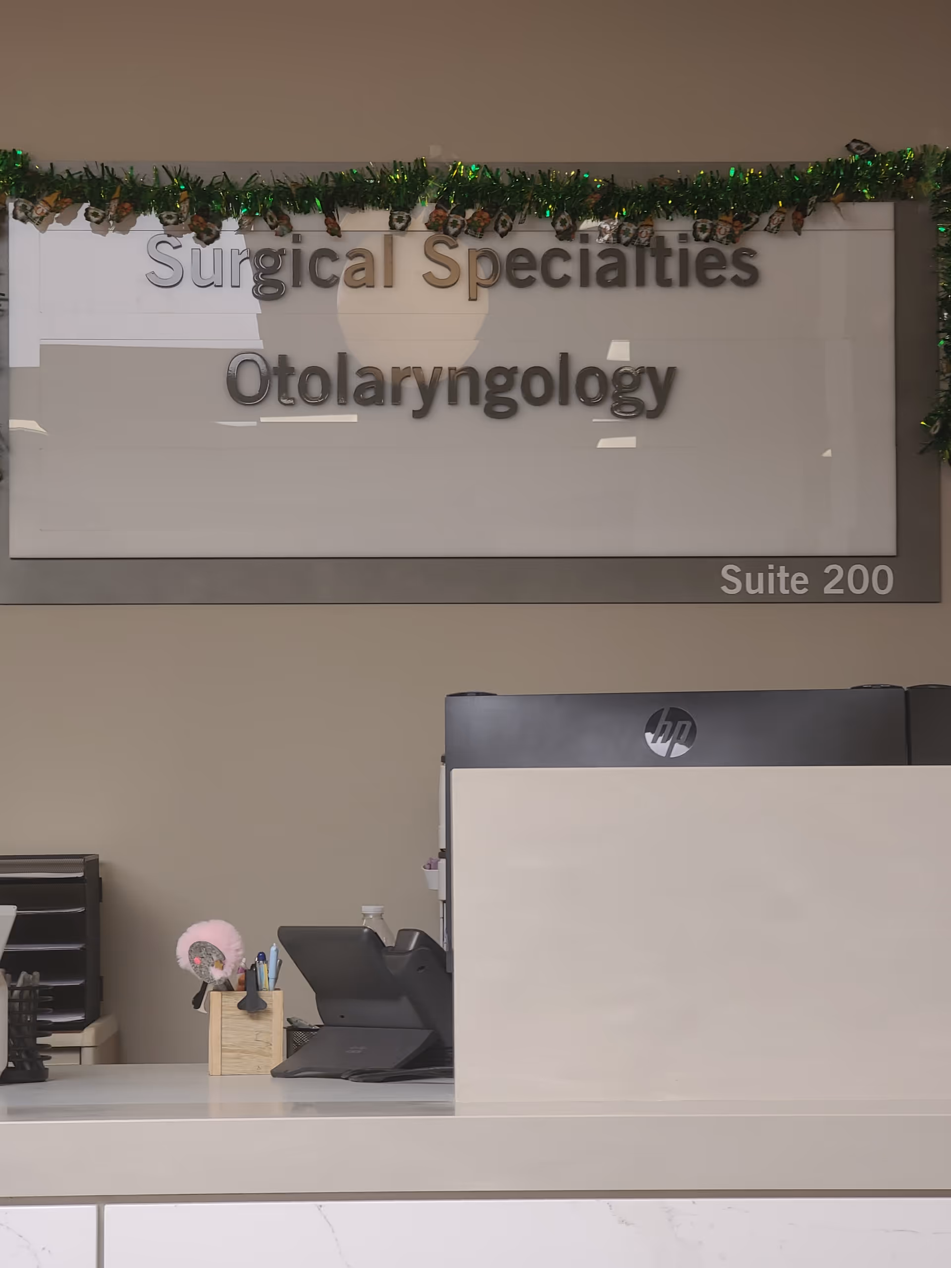 Reception desk in a medical office lobby with garland and Surgical Specialties Otolaryngology sign