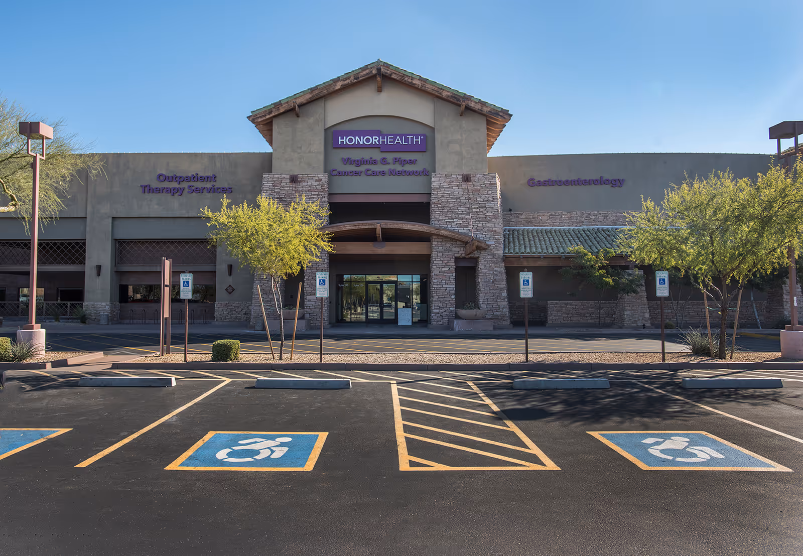 Exterior view of HonorHealth Outpatient Therapy building with parking lot and trees.