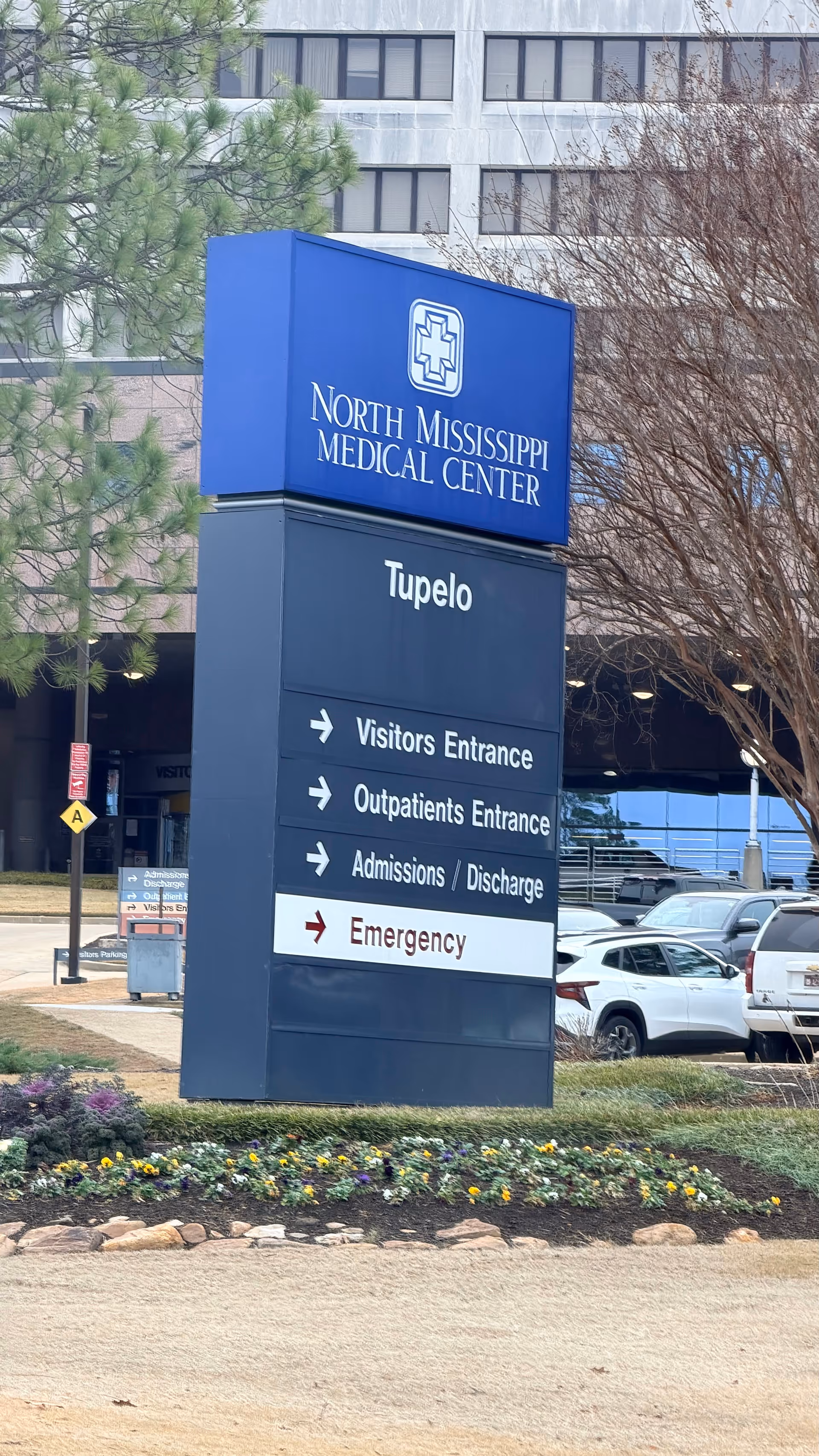 A tall blue sign shows North Mississippi Medical Center Tupelo with entrance directions outside the hospital.