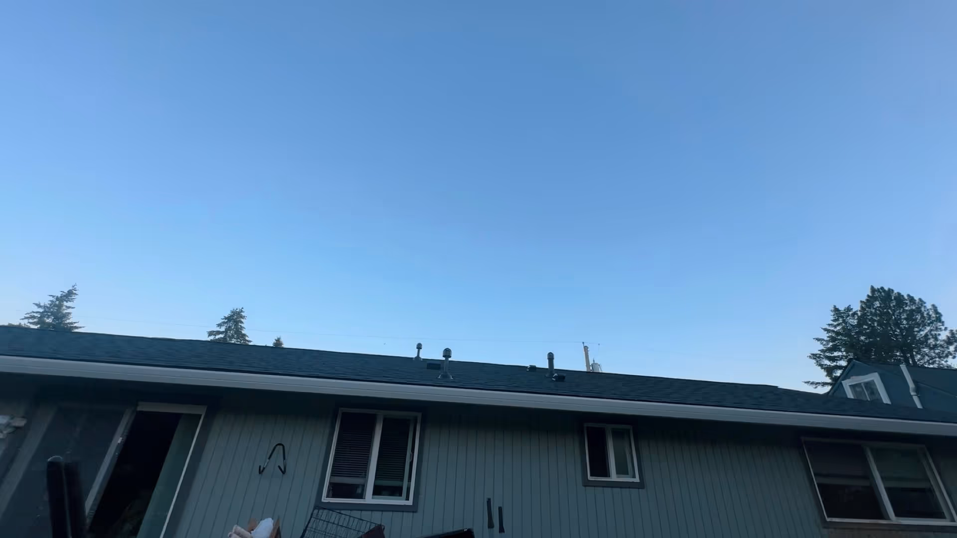 Blue-sky exterior view of a single-story building with windows and light blue siding