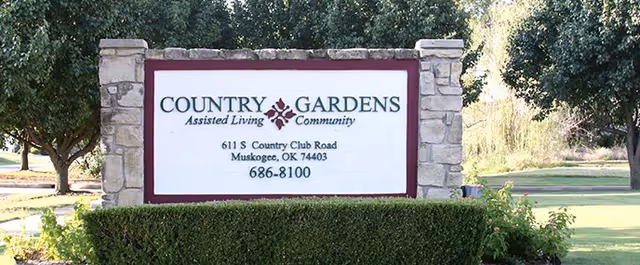 Exterior view of the Country Gardens Assisted Living entrance sign with landscaping.