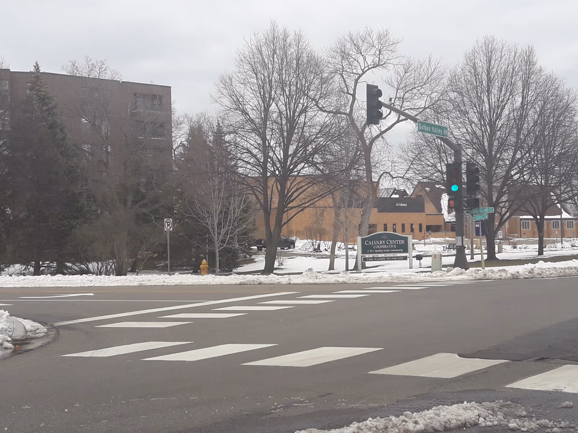 Exterior of Calvary Center Cooperative on a snowy street with crosswalk and traffic light.