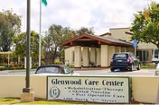 Front view of Glenwood Care Center with sign and parked cars near entrance