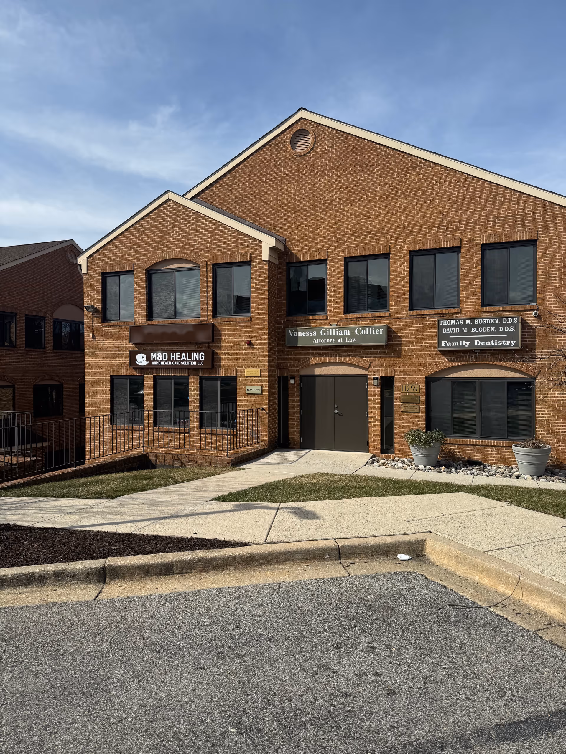 Brick two-story building with multiple medical and dental signs along the front facade.