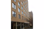 Brick senior living building with multiple windows and ground-floor entrances.