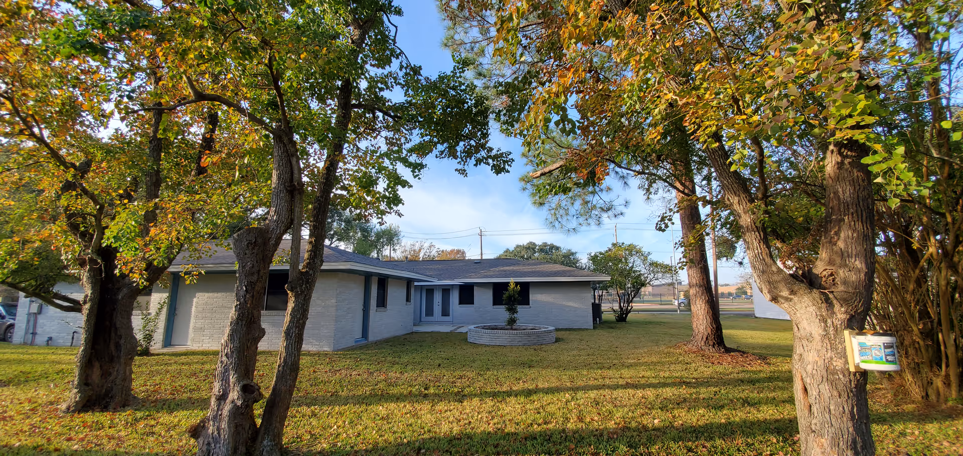 Exterior of Senior Link Assisted Living, a single-story building with trees and lawn.