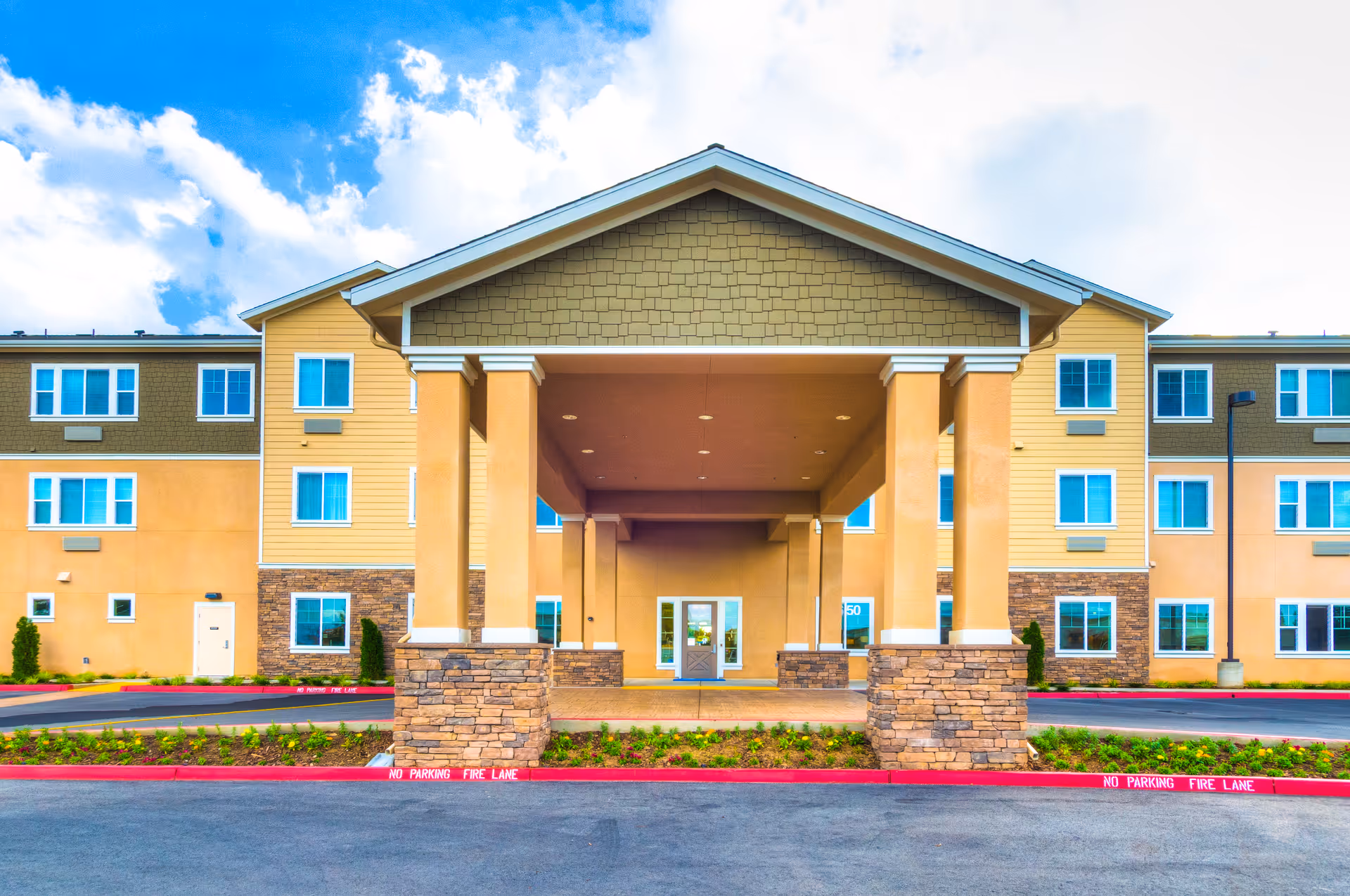 Front view of a modern senior living facility with a covered entrance.