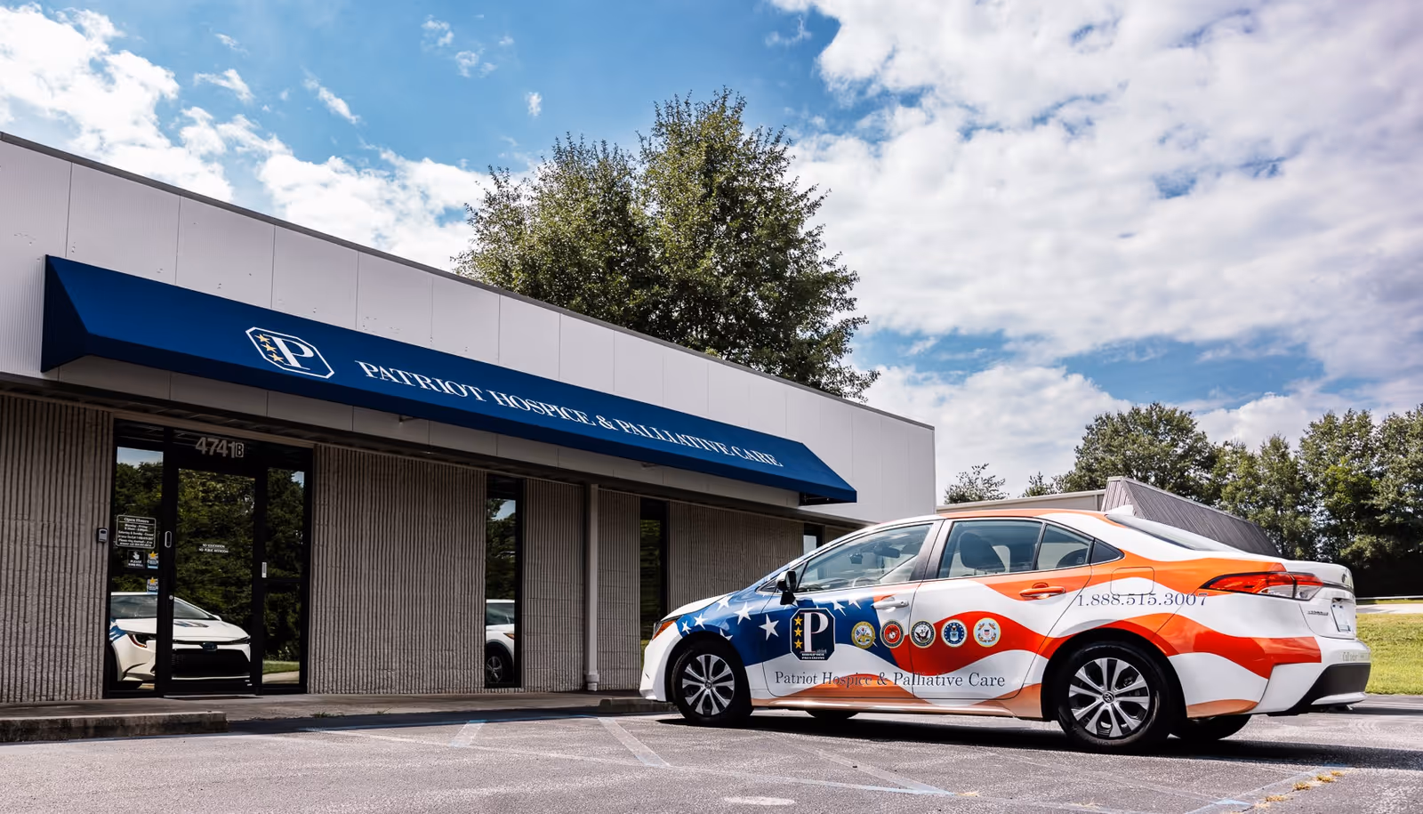 Exterior view of Patriot Hospice and Palliative Care building with a patriotic car parked in front.