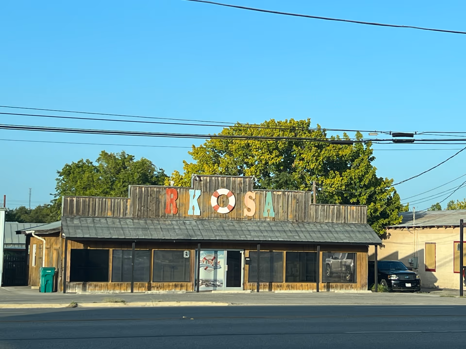 Rustic storefront with a colorful RKOSA sign and a street-view facade.