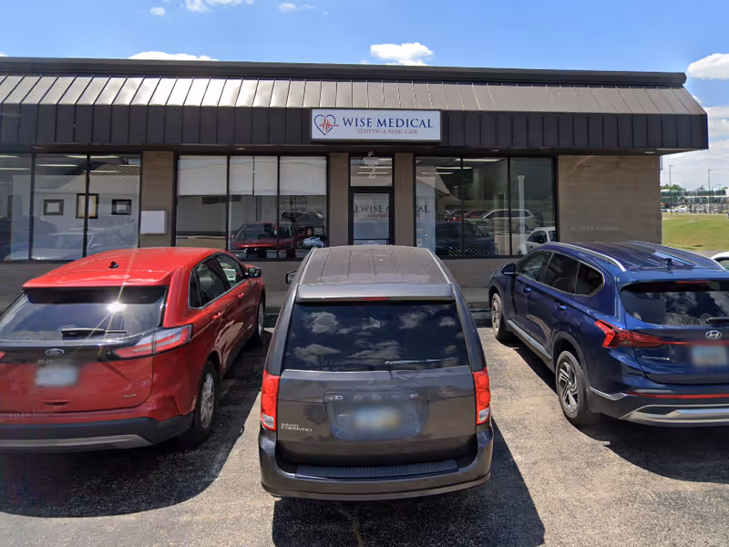 Exterior view of Wise Medical Staffing clinic with signage and parked cars in front.