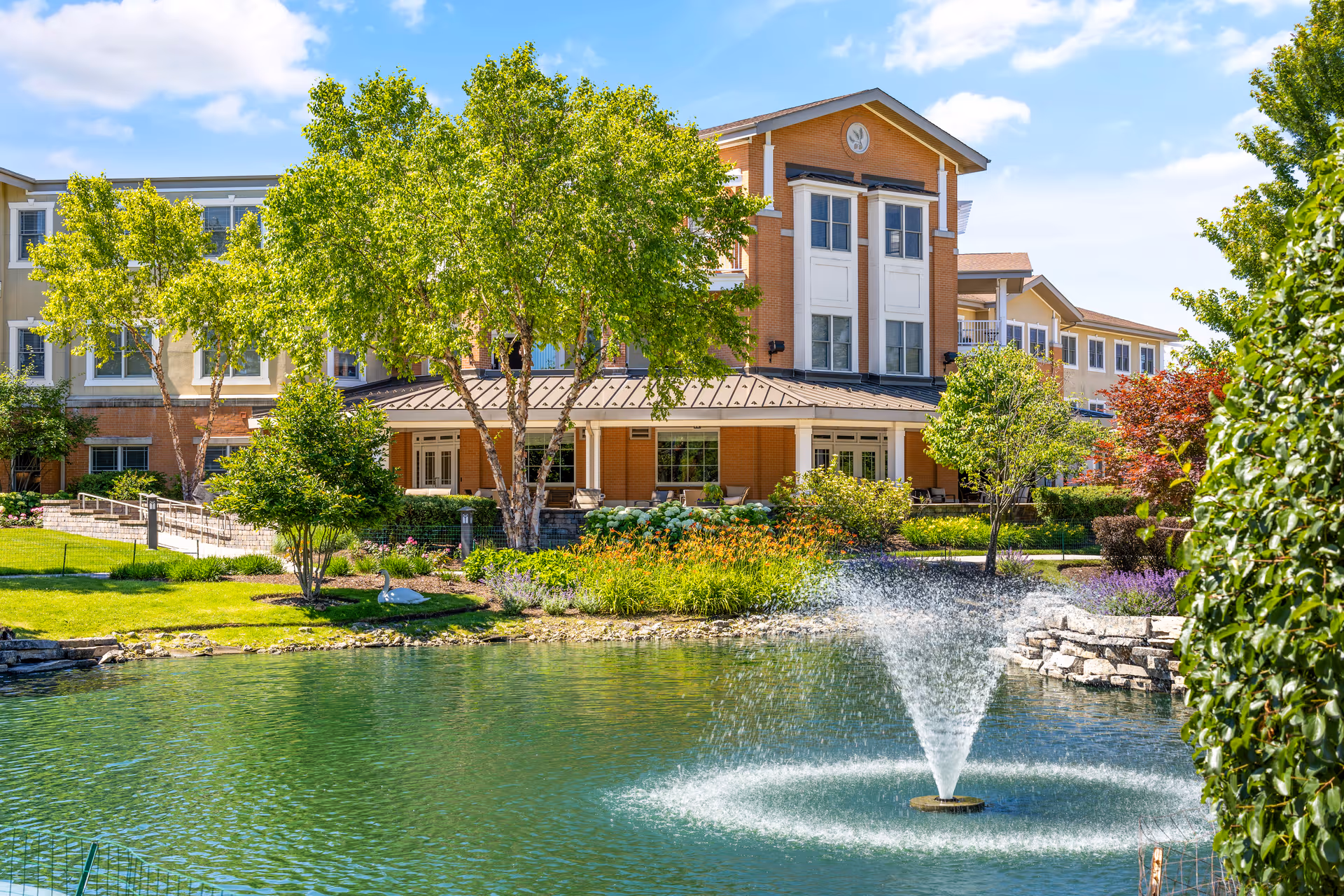 Exterior view of Covenant Living of Northbrook with pond, fountain, and landscaped grounds.
