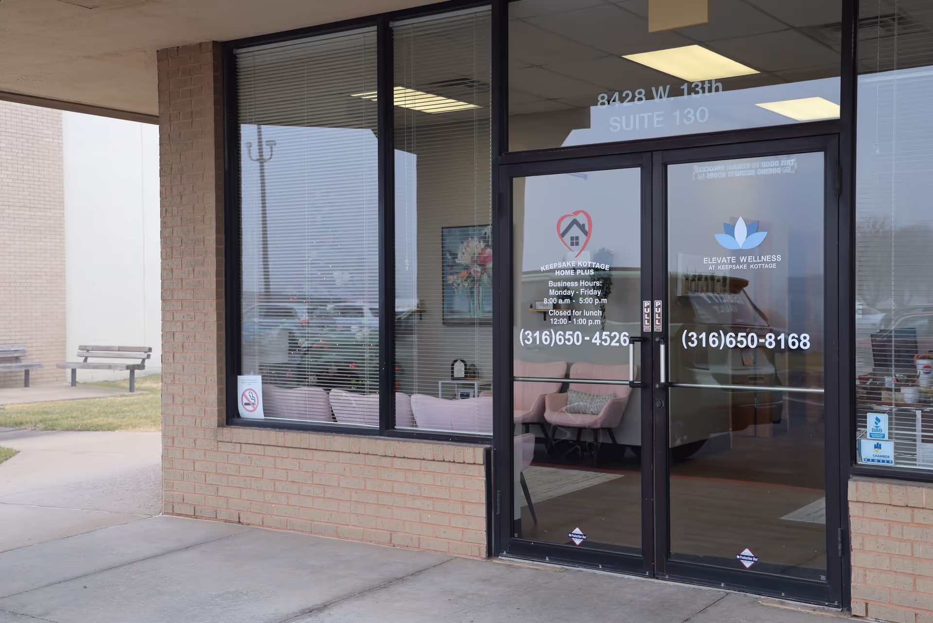 Keepsake Kottage entrance with glass doors, brick exterior, and outdoor seating.