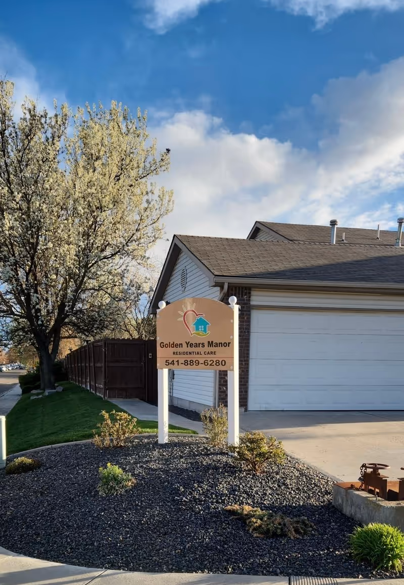 Exterior view of a senior living facility with a sign saying Golden Years Manor in front.