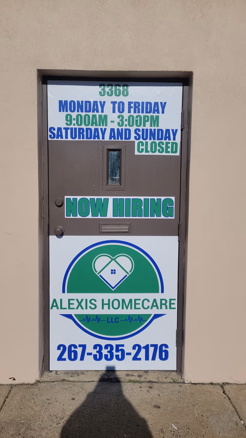 Exterior door with a sign for Alexis Homecare Now Hiring and contact info