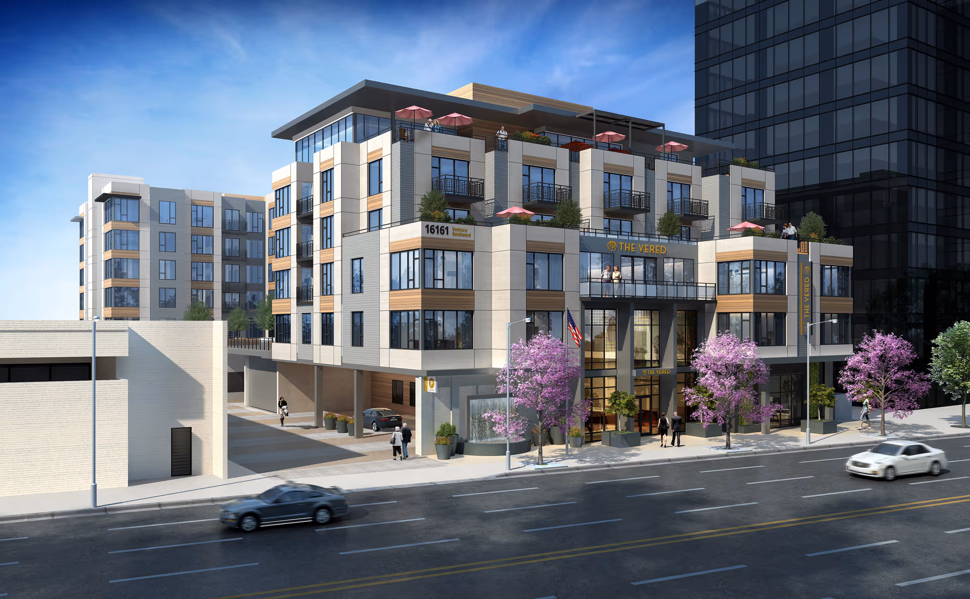 Modern senior living building The Vered viewed from the street with trees and parked cars.