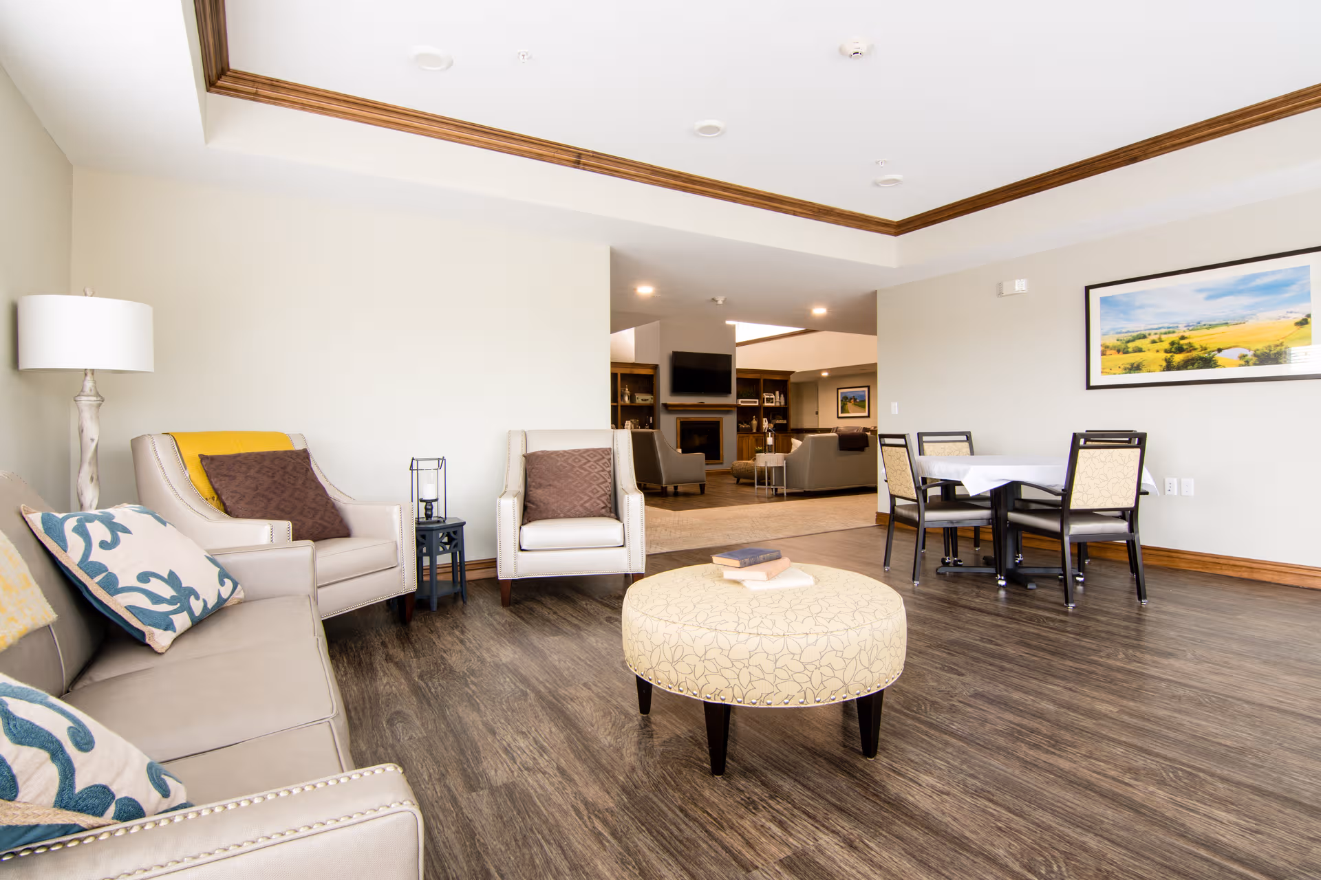 Spacious senior living common area with couches, chairs, a coffee table, and dining nook.