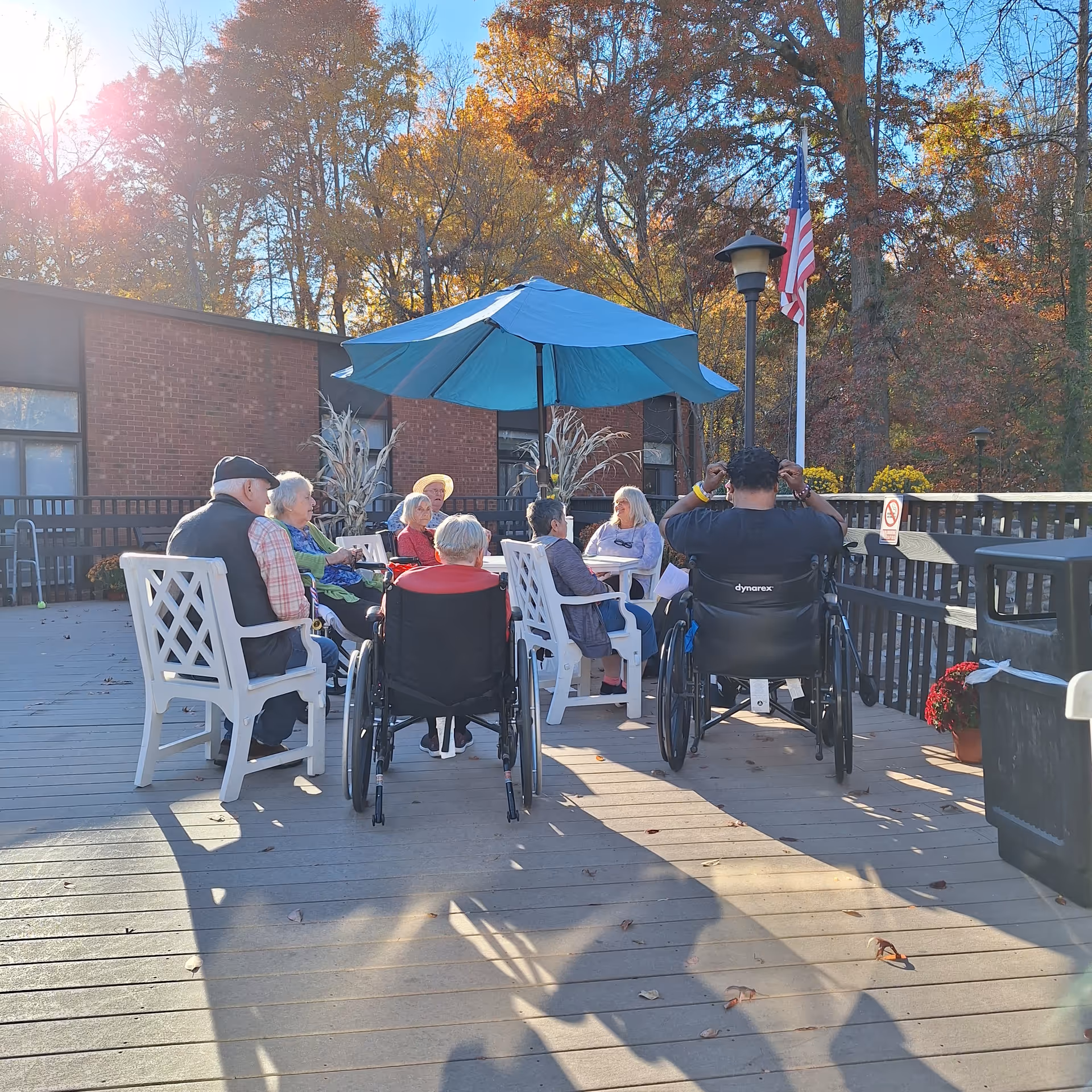 Residents socialize outdoors around a shaded seating area at Spring Grove