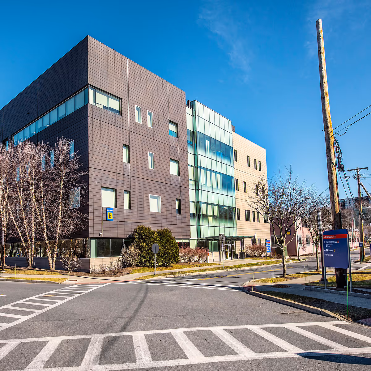 Modern multi-story medical building with glass facade under a clear blue sky.