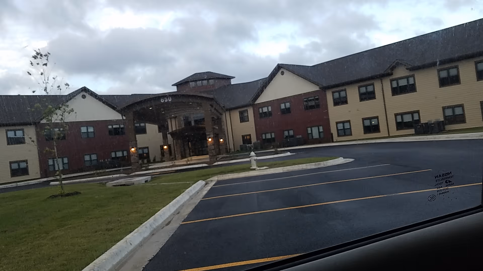 Exterior view of Primrose Retirement Community of Rogers with curved entryway.
