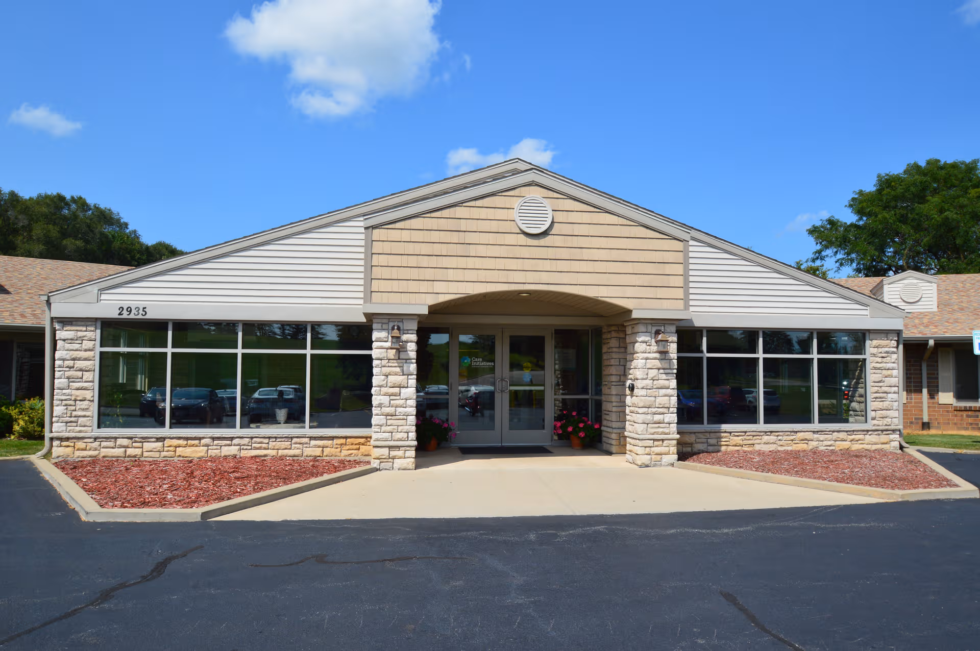 Front view of Dubuque Specialty Care facility with glass doors and stone columns.