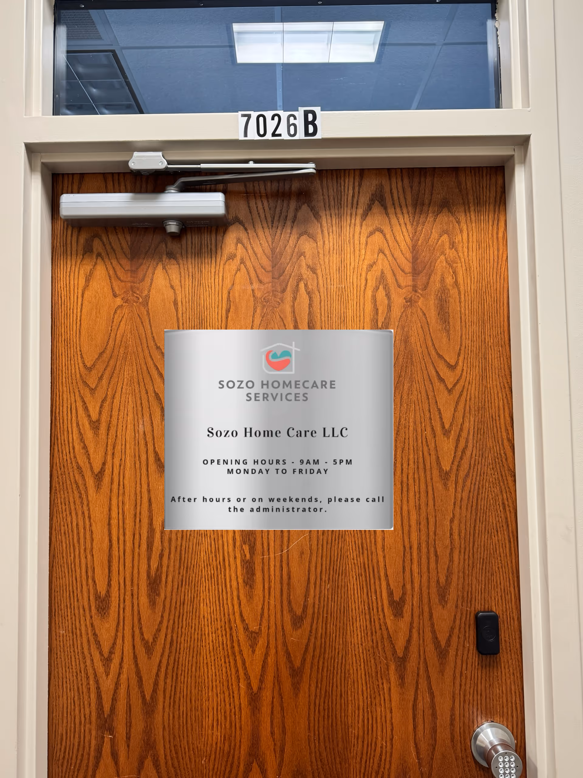 Wooden door with metal sign for Sozo Home Care LLC and building number 7026B.