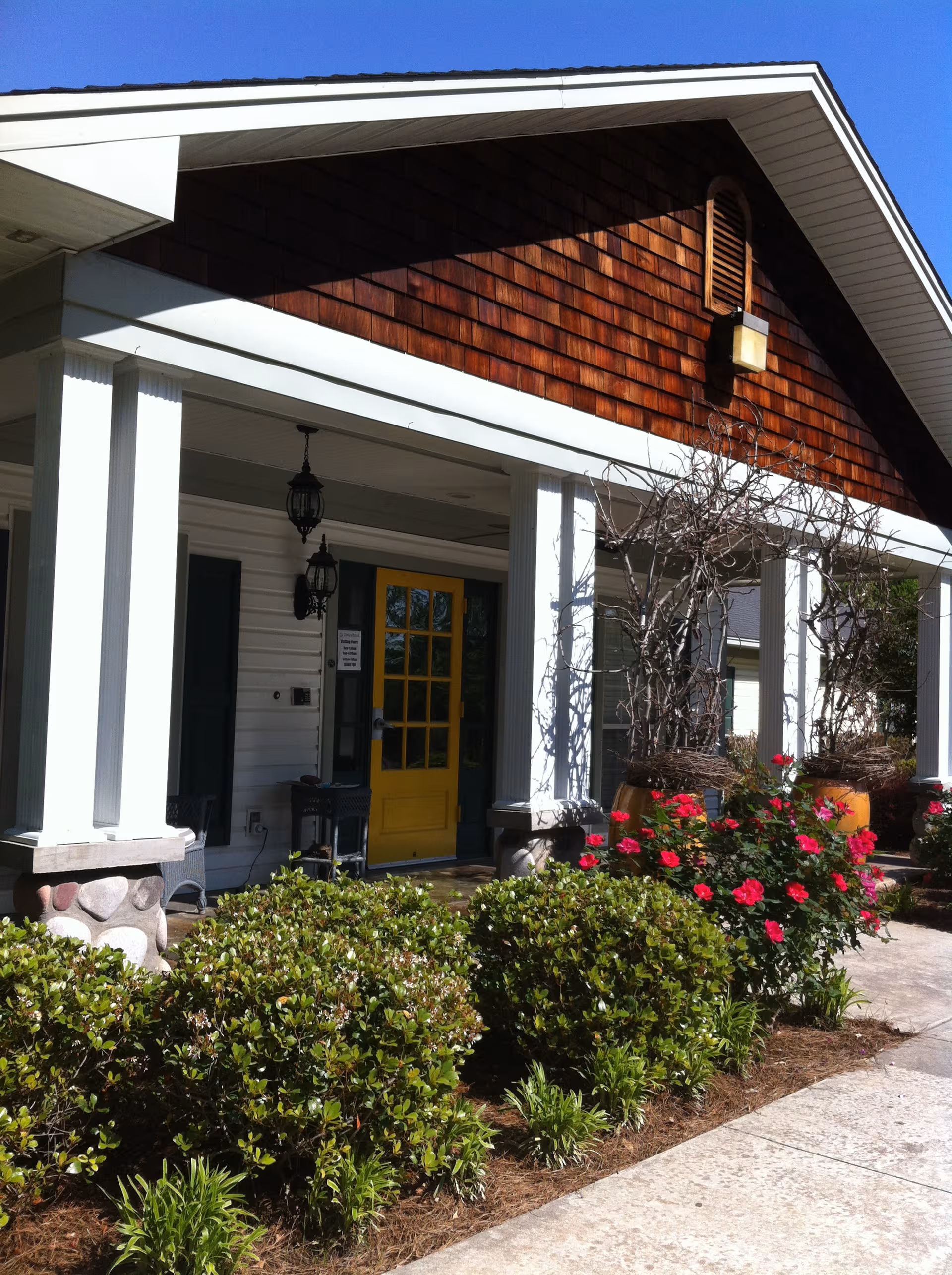 Stoneybrook Memory Care Home entrance with yellow door and landscaped front garden.