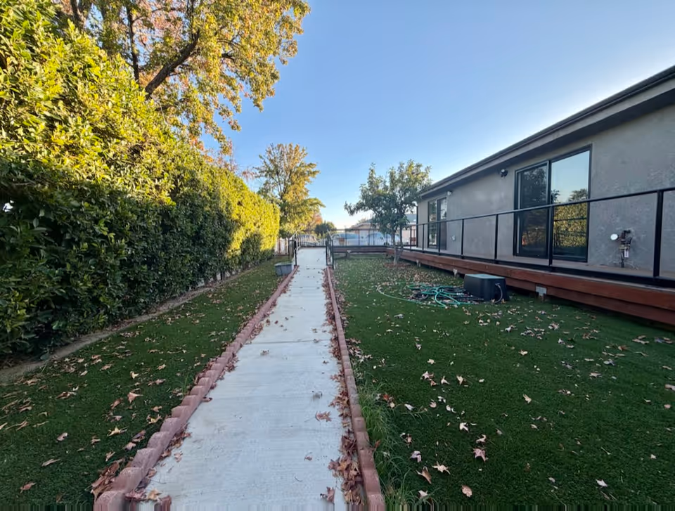 Exterior view of Eternal Life Assisted Living with walkway, lawn, and hedges