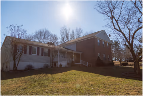 Exterior view of Able Plus Assisted Living building with a small front porch and yard