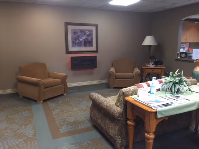 Cozy lounge area in Deaconess Tower Assisted Living with seating, plants, and magazines.