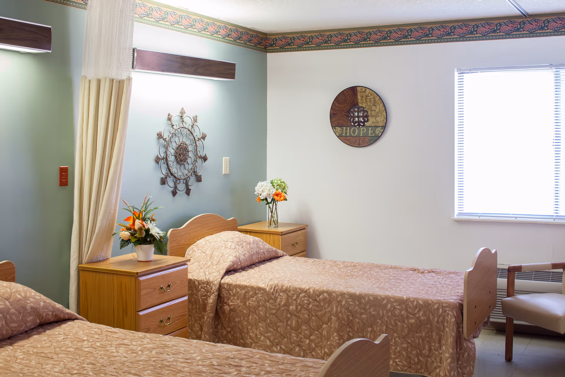 Two twin beds with beige quilts and matching nightstands in a pastel bedroom.