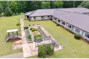 Aerial view of a single-story nursing facility with a central courtyard and landscaped paths.