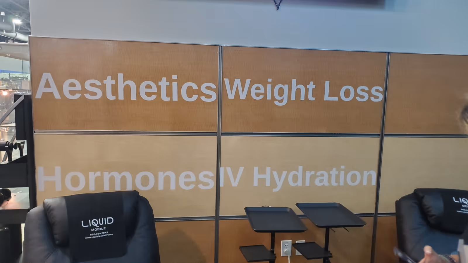 Interior clinic seating area with branded chairs and large wall panels advertising aesthetics and hydration.