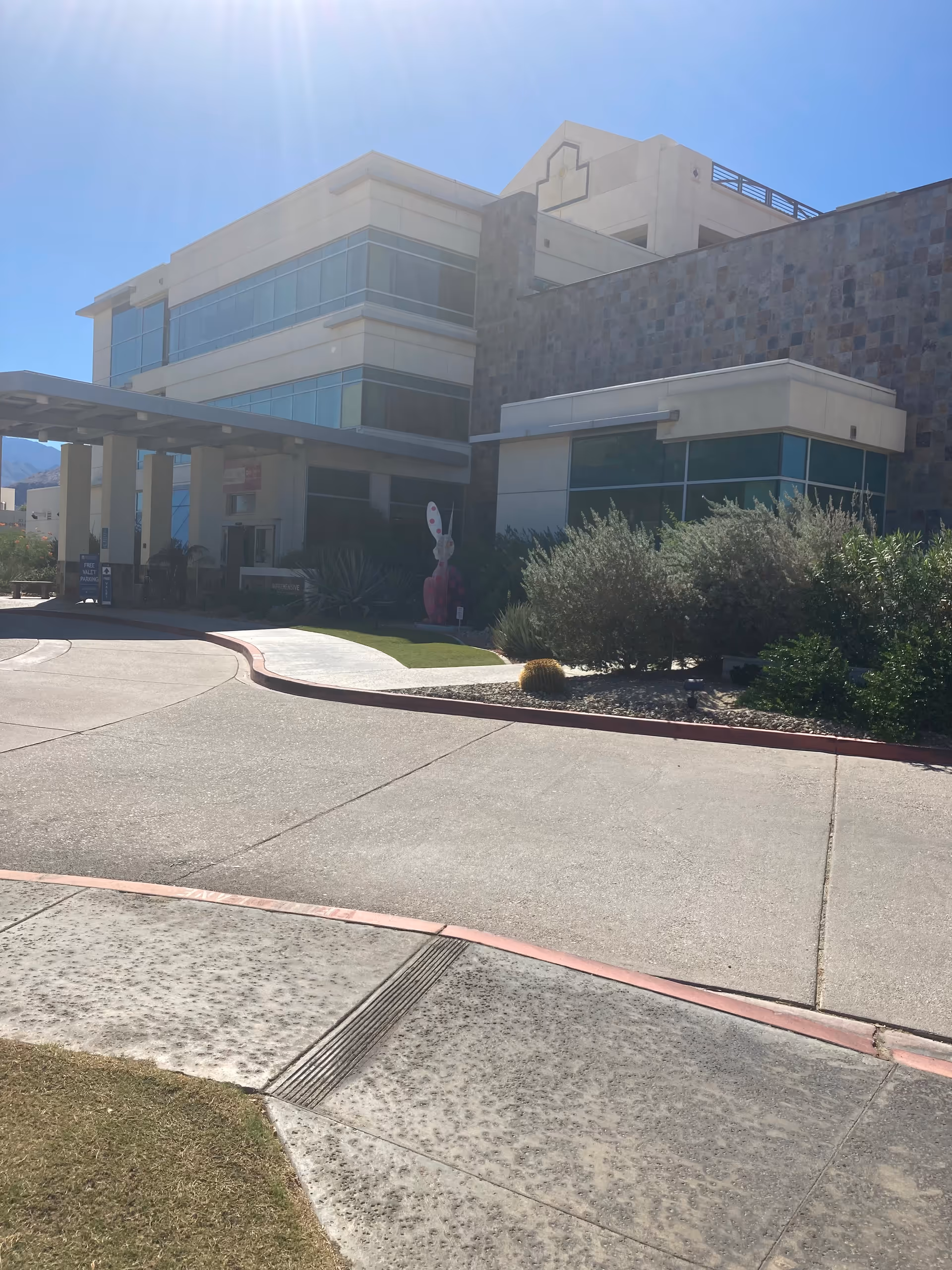 Exterior view of a modern medical center with glass windows and landscaped entrance.