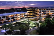 A multi-story senior living facility at dusk with a lit central courtyard.